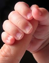 Bebé coge un dedo con su mano